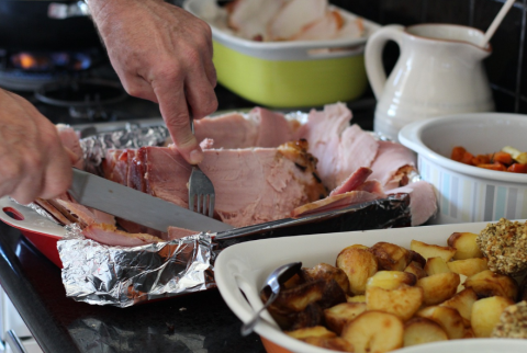 A person cuts into holiday food on a table